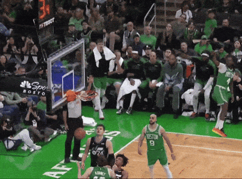 basketball players on a court with a scoreboard that says boston