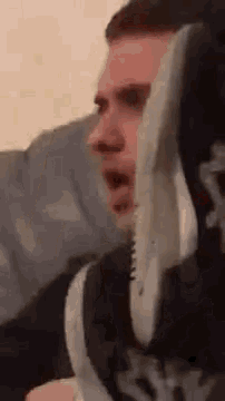 a man is wearing a pair of shoes on his head .
