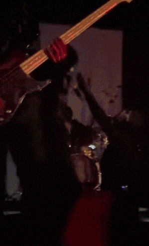 a person playing a guitar in a room with a microphone