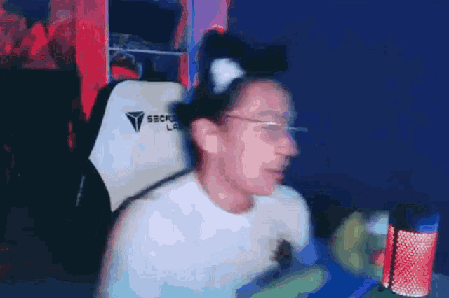 a man wearing a cat ear headband is sitting in a chair