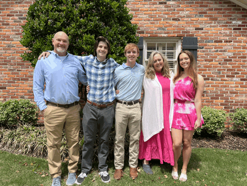 a family posing for a picture in front of a brick wall