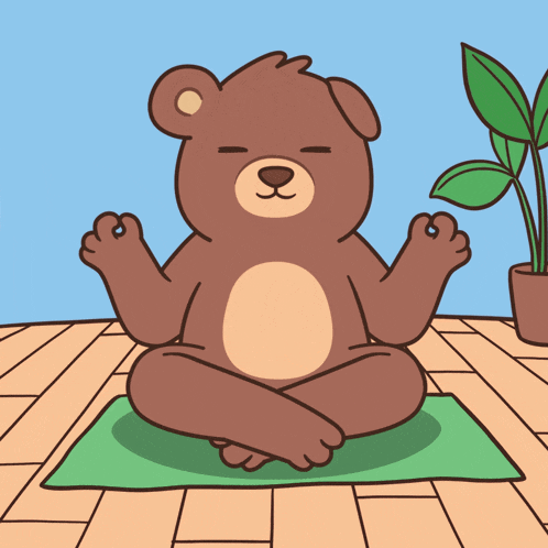 a brown teddy bear sits on a yoga mat with its eyes closed