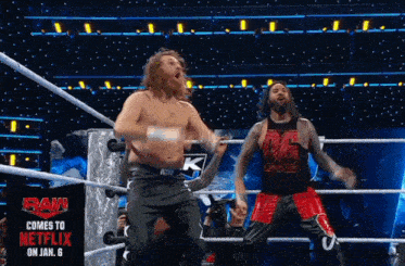 two wrestlers in a ring with a sign that says raw comes to netflix