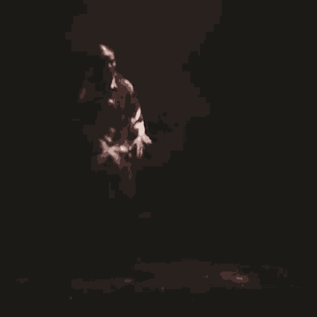 a man is standing in the dark in a dark room .