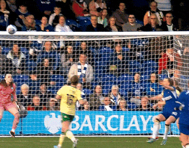 a soccer game is being played in front of an ad for barclays