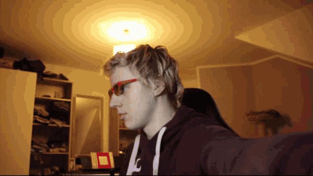 a man wearing sunglasses and a hoodie with the letter c on the front