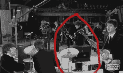 a group of men are playing instruments on a stage in a black and white photo .