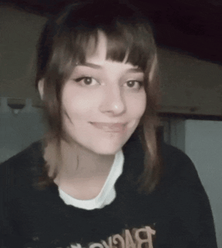 a close up of a woman 's face with a black shirt that says ' bvc ' on it