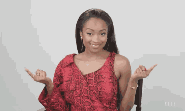 a woman in a red snake print dress is sitting in a chair with elle written on the bottom