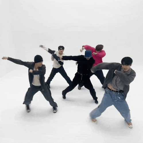 a group of young men are dancing together in a white room