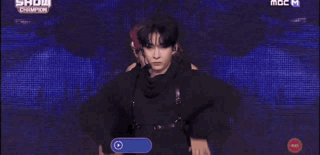 a group of young men are dancing on a stage in front of a crowd .