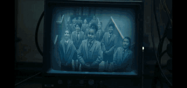 a black and white photo of a group of children on a tv screen