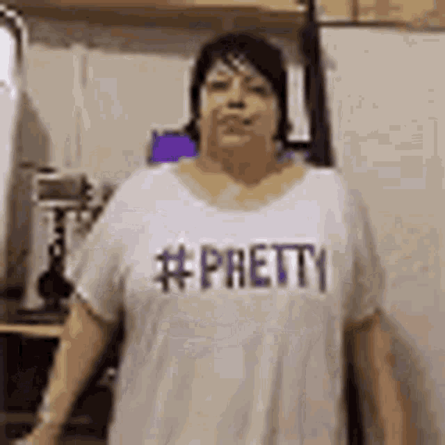 a woman is wearing a white t-shirt that says pretty .