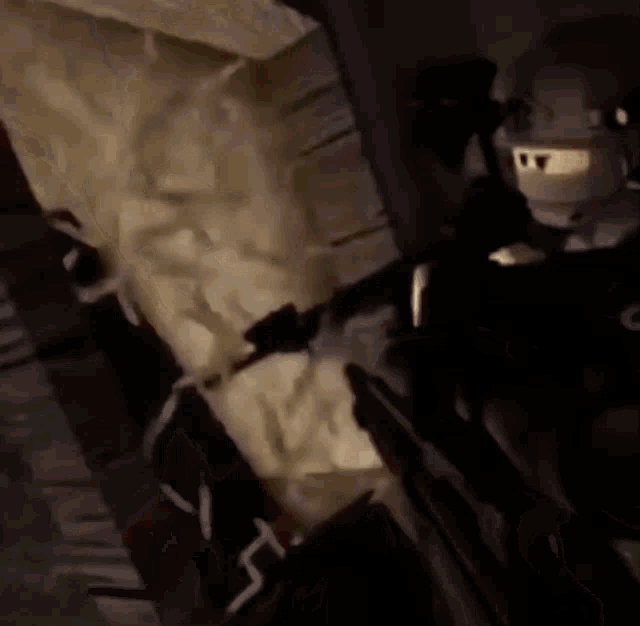 a man in a mask is holding a gun in a dark room