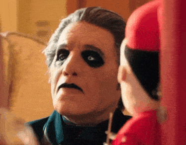 a man in a ghost costume is looking at himself in a mirror .