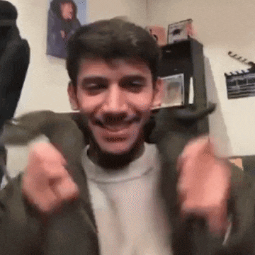 a man with a beard is smiling and making a funny face .