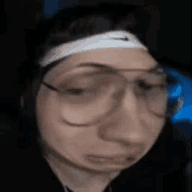 a close up of a person wearing glasses and a nike headband .