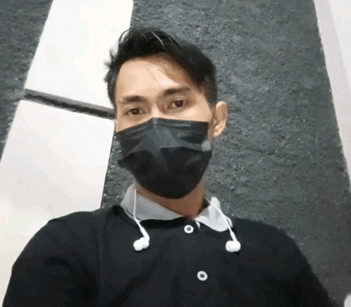 a man wearing a black face mask and earbuds
