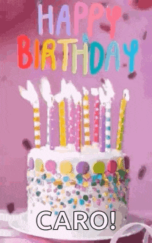 a birthday cake with candles and sprinkles on it is on a plate on a table .