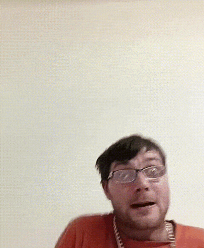 a man wearing glasses combs his hair with a comb