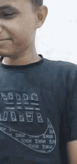 a man wearing a black nike t-shirt smiles with his eyes closed