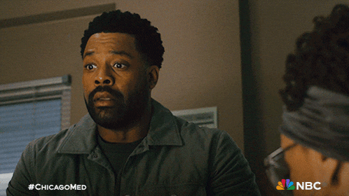 a man with his arms crossed looks at a woman with glasses in a nbc ad for chicagomed
