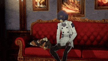 a man is sitting on a red couch with a dog