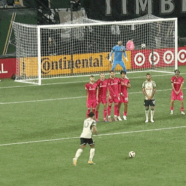a group of soccer players on a field in front of a continental banner