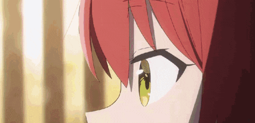 a close up of a girl with red hair and green eyes .