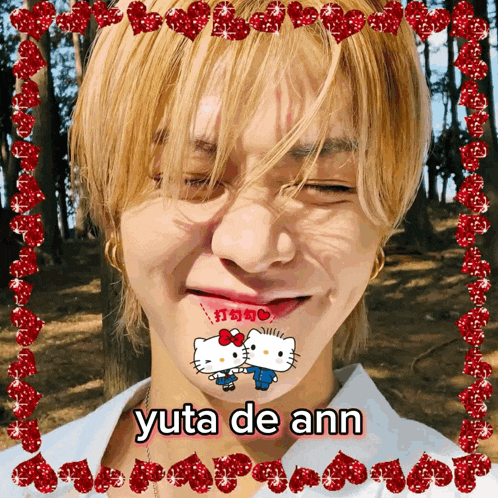 a picture of yuta de ann with hello kitty and hearts on his face