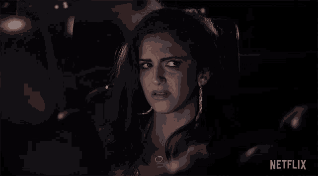 a woman sitting in a car with a netflix logo on the bottom right