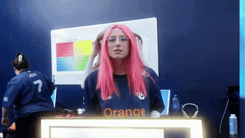 a girl with pink hair is standing in front of a sign that says orange