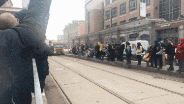 a group of people standing on a sidewalk in front of a building that says columbia bank