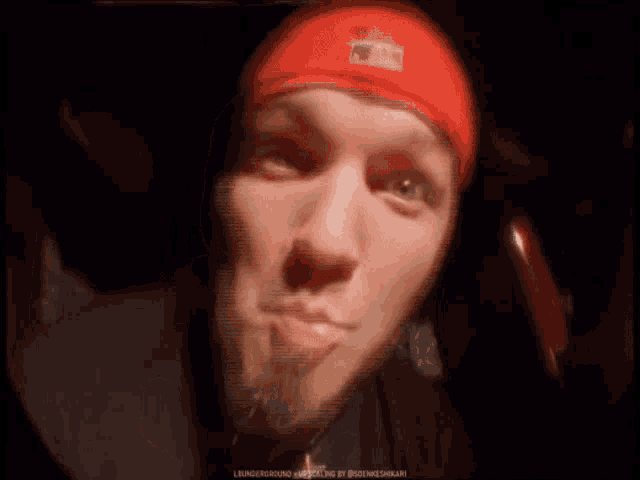 a man wearing a red nike headband making a face