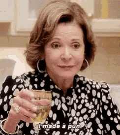 a woman is holding a glass of wine and making a funny face .