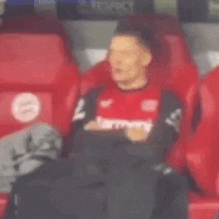 a man in a red shirt is sitting in a red seat .