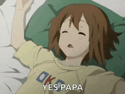 a girl is laying on a bed with her eyes closed and a shirt that says ok on it .
