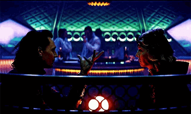 a man and a woman are standing next to each other in a dark room holding sparklers .