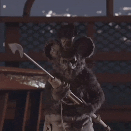 a mouse holding a stick with the letter x on the bottom