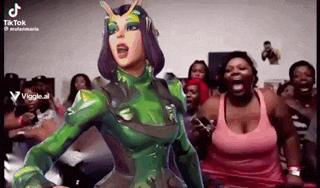 a woman in a green costume is standing in front of a group of people .