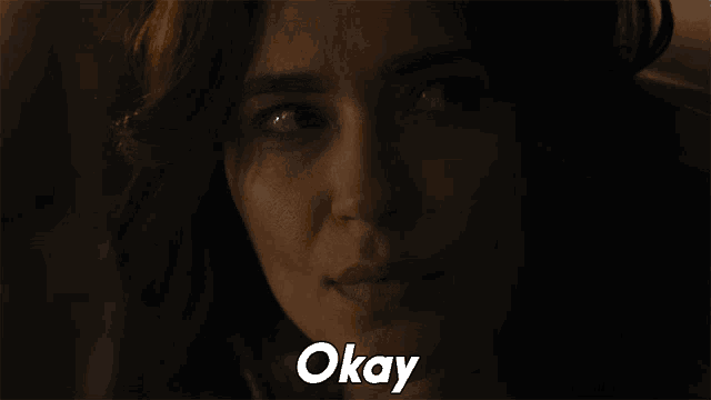 a close up of a woman 's face with the word okay in white