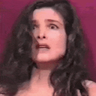 a woman with long hair is making a funny face .