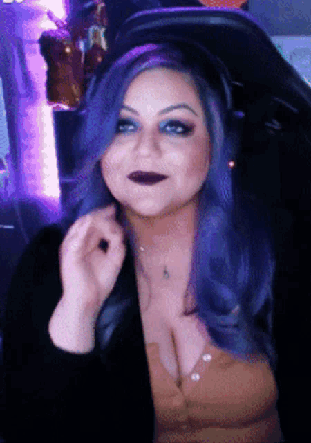 a woman with purple hair is sitting in a chair with headphones on her head