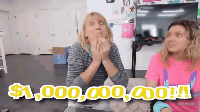 two women are sitting at a table and one of them is wearing a pink shirt that says ' i love you ' on it