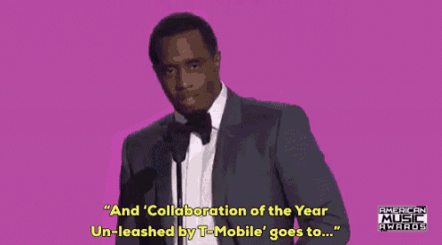 a man in a suit and bow tie is giving a speech at an american music awards ceremony .