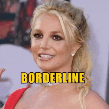 britney spears is smiling and giving a thumbs up while wearing a red dress and a choker necklace .