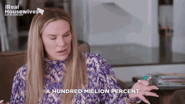 a woman says a hundred million percent in front of a real housewives sign