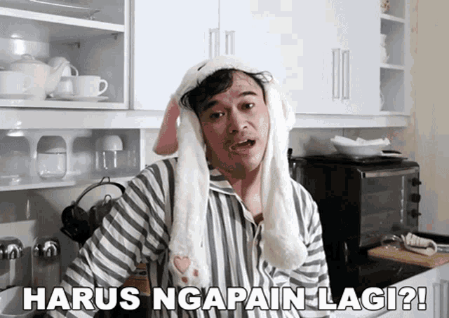 a man wearing bunny ears and the words harus ngapain lagi on the bottom