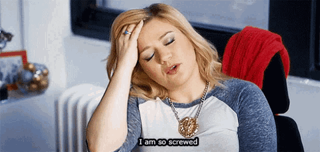 a woman is sitting in a chair with her hand on her forehead and says i am so screwed .