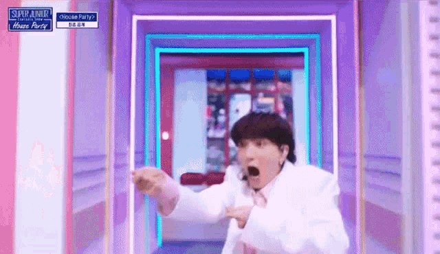 a man in a white jacket is standing in a room with a sign that says ' house party ' on it .